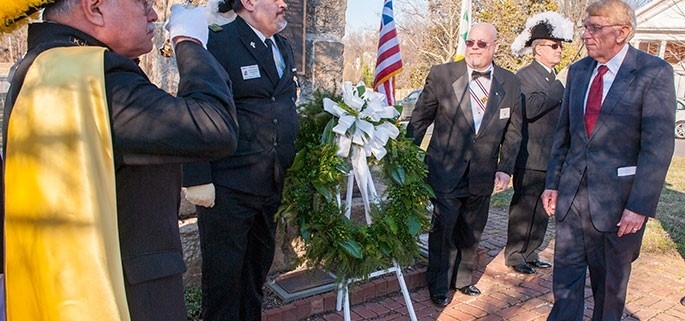 William Murray lays wreath at memorial during celebration of religious freedom, as honor guard from the Knights Templar and Knights of Columbus salute.