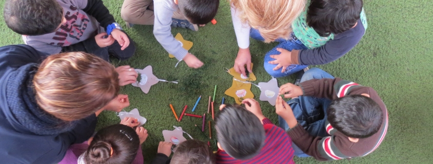 A small group of children make star ornaments as a project during a Christmas for Refugees event at a Nazarene Church in Lebanon. Christmas, 2017
