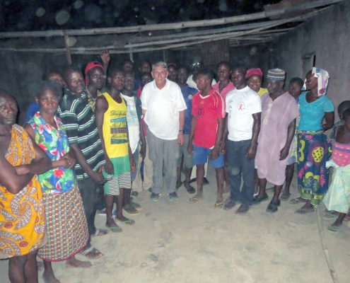 William J. Murray with survivors of the Agatu church massacre. Note that the roof is missing. The inside of the church was set on fire so there are no pews or chairs.